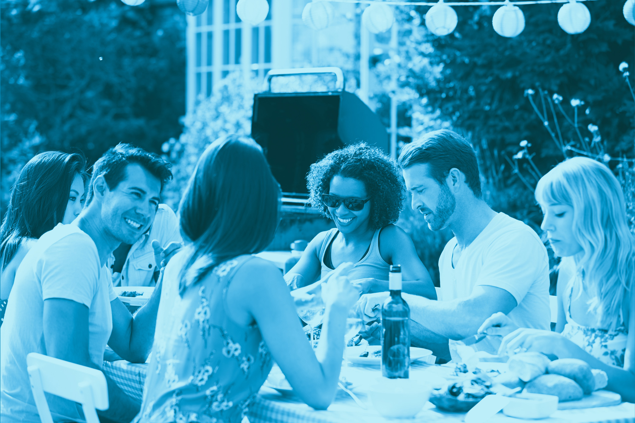 A group enjoys a meal outdoors with drinks and food, a barbecue grill behind them—nearby, the Louisiana chemical industry shapes the local scene.